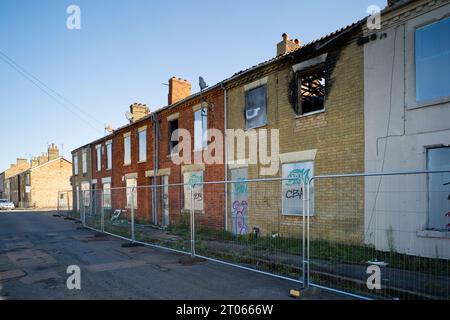 A row of abandoned terraced houses in Cromwell Road, Peterborough with one showing signs of a fire32q` Stock Photo